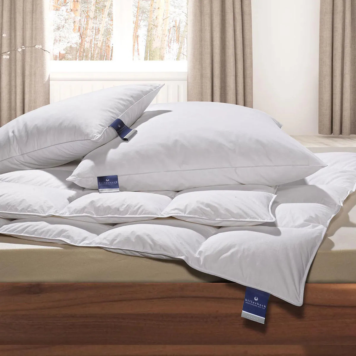 Billerbeck ALMIRA® Light Sommerdecke mit Kissen auf Bett, im Hintergrund Fenster mit Winterlandschaft