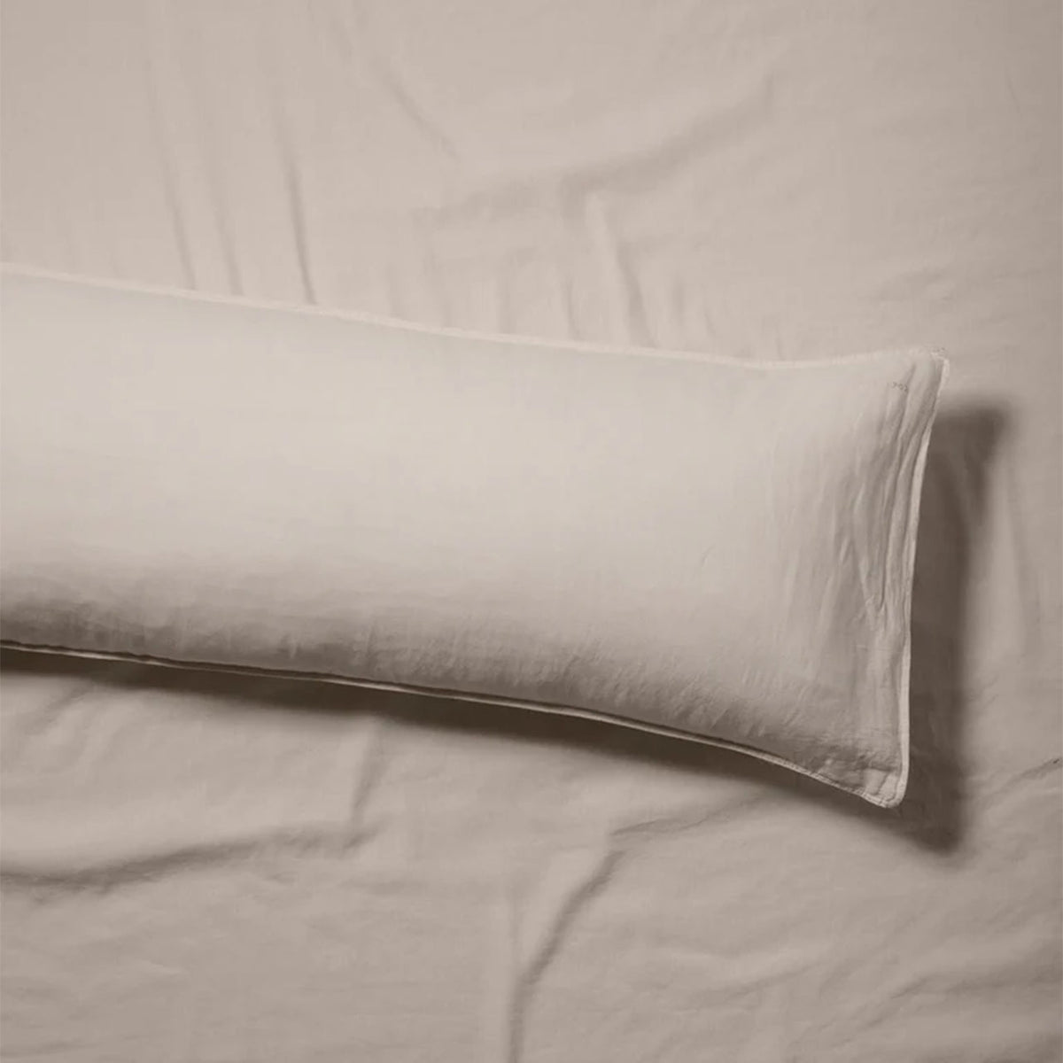 Suite702 bedMATE Leinen-Mix Kissenbezug in Dune, langes Seitenkissen auf dem Bett liegend