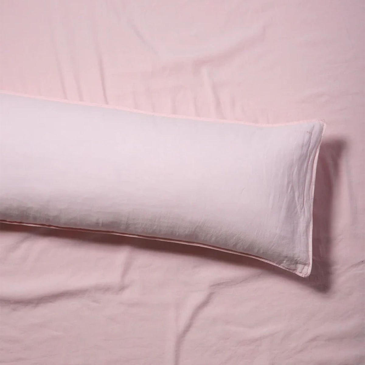 Suite702 bedMATE Leinen-Kissenbezug in Shell Pink, Seitenkissen liegend auf rosa Bettwäsche