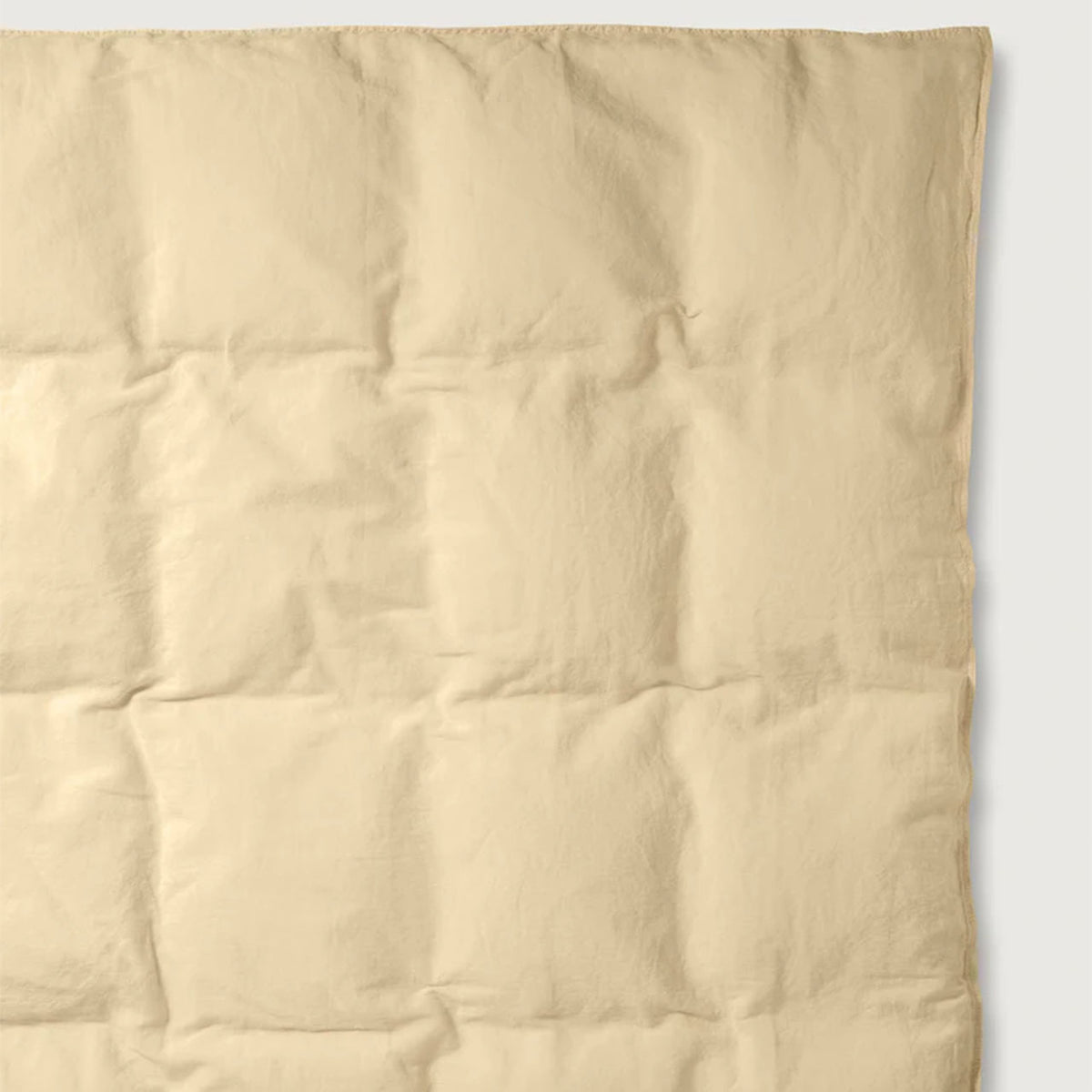 Nahaufnahme des Suite702 Leinen-Mix Bettdeckenbezugs in Creamy Yellow mit sichtbarer Steppung und Kettelrand