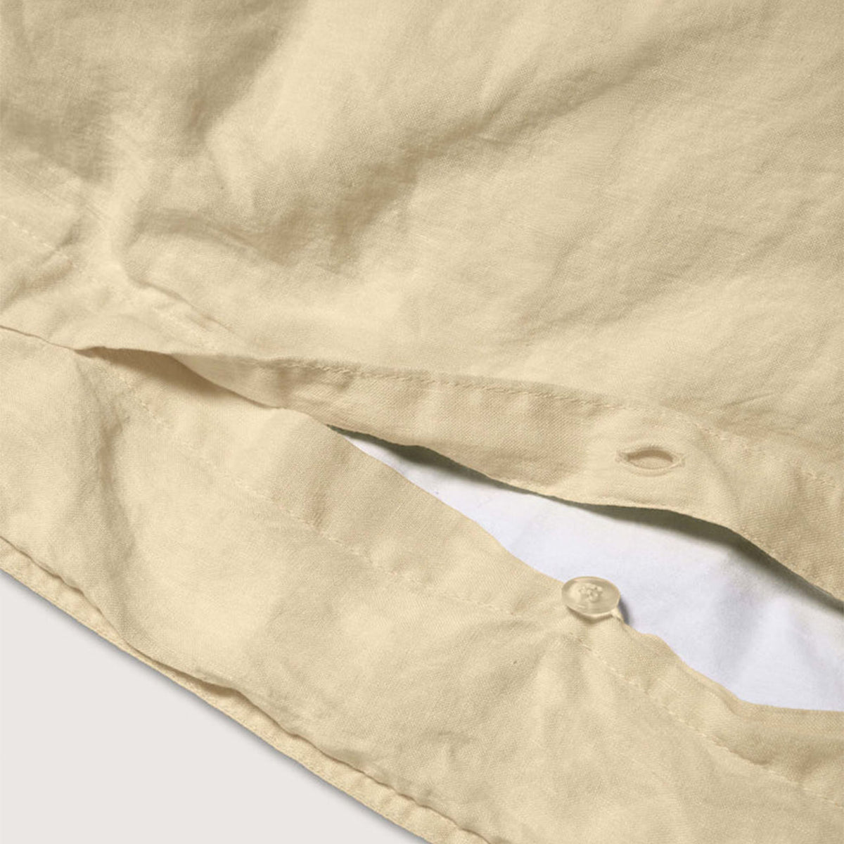 Nahaufnahme der Knopfleiste des Suite702 Leinen-Mix Bettdeckenbezugs in Creamy Yellow