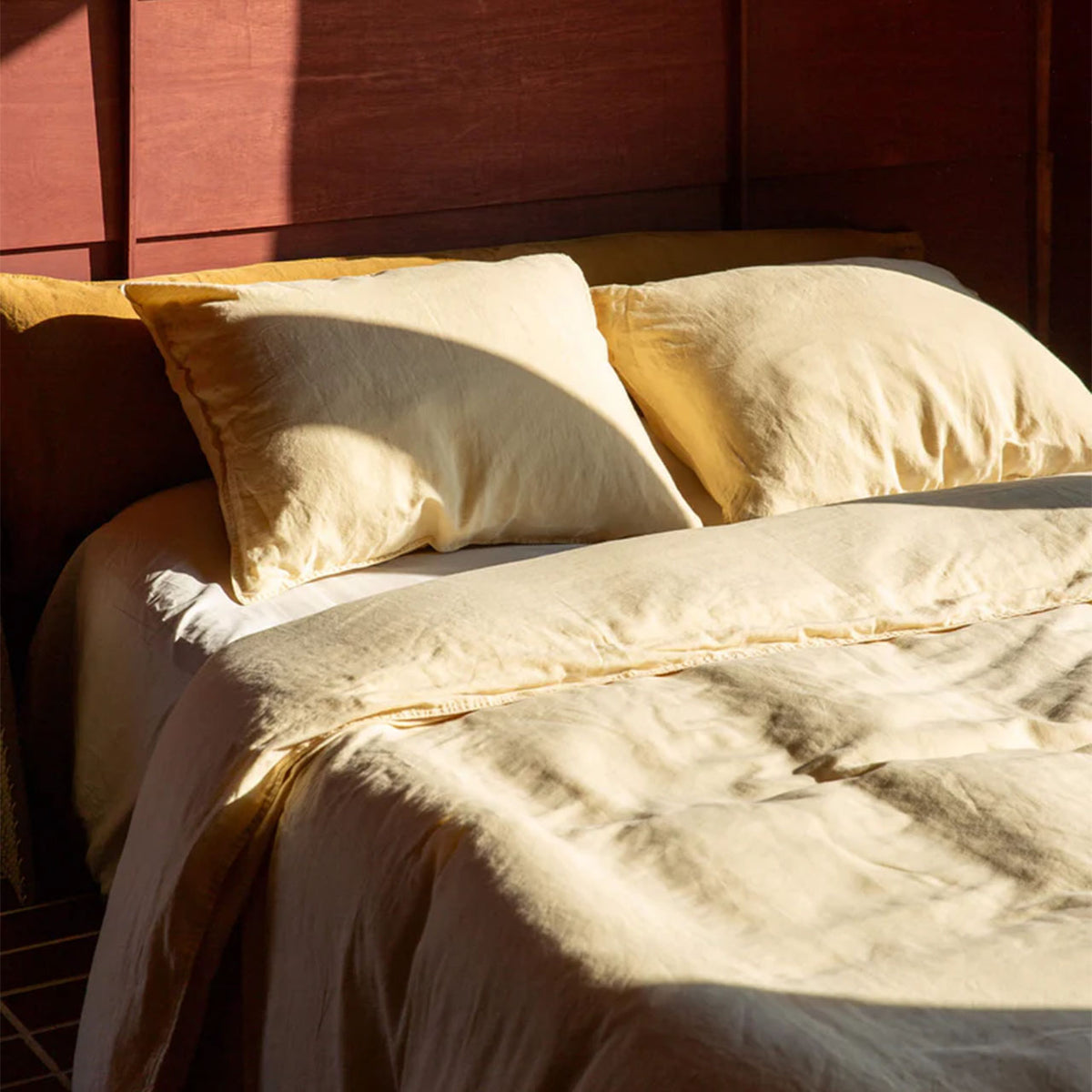 Suite702 Leinen-Mix Bettdeckenbezug in Creamy Yellow mit passenden Kissenbezügen im Sonnenlicht auf dem Bett