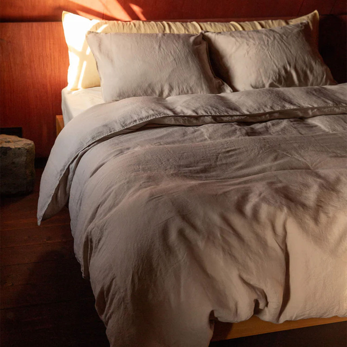 Suite702 Leinen-Mix Bettdeckenbezug in Dune mit Kissenbezügen auf Bett im warmen Licht