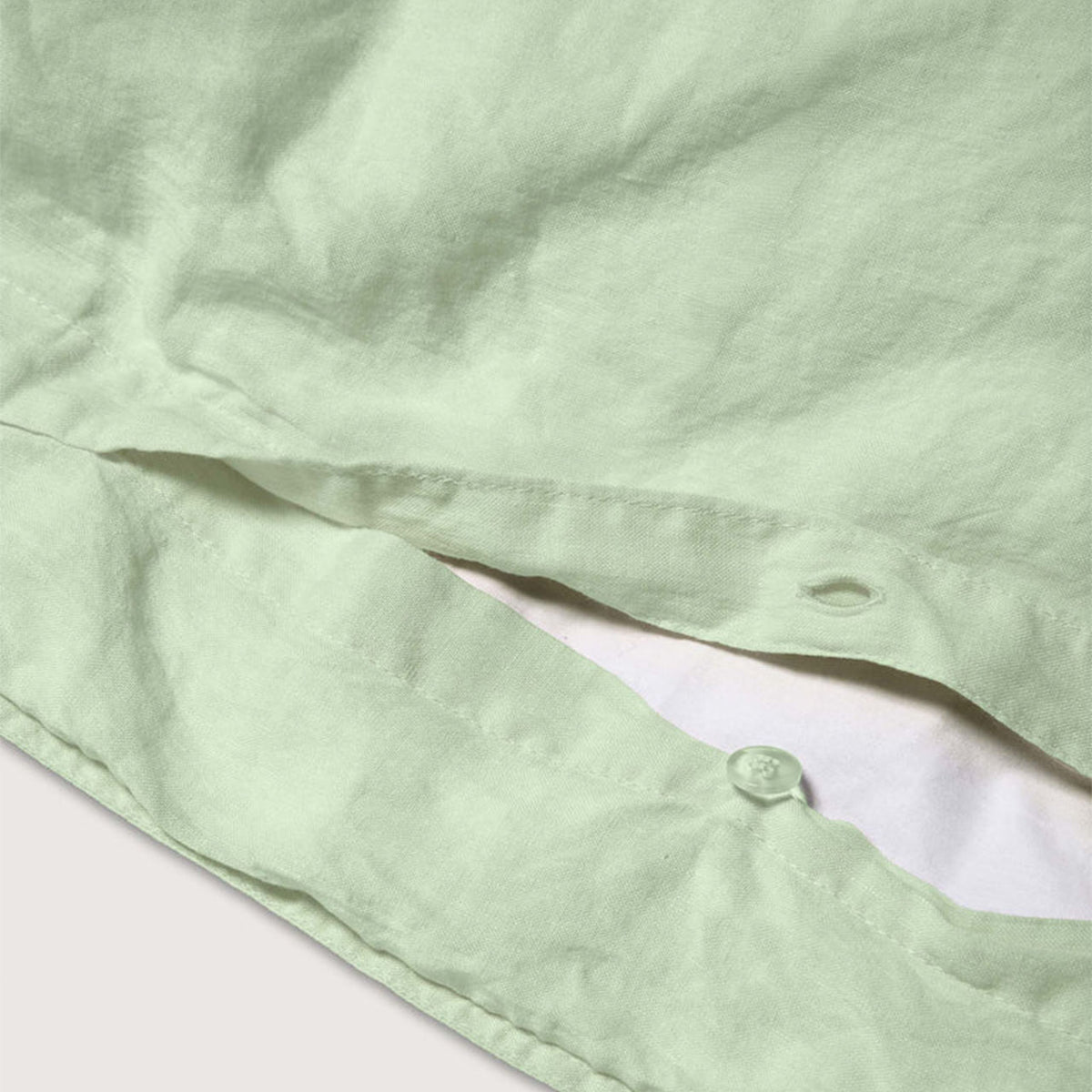 Nahaufnahme der Knopfleiste des Suite702 Leinen-Mix Bettdeckenbezugs in Green Mint