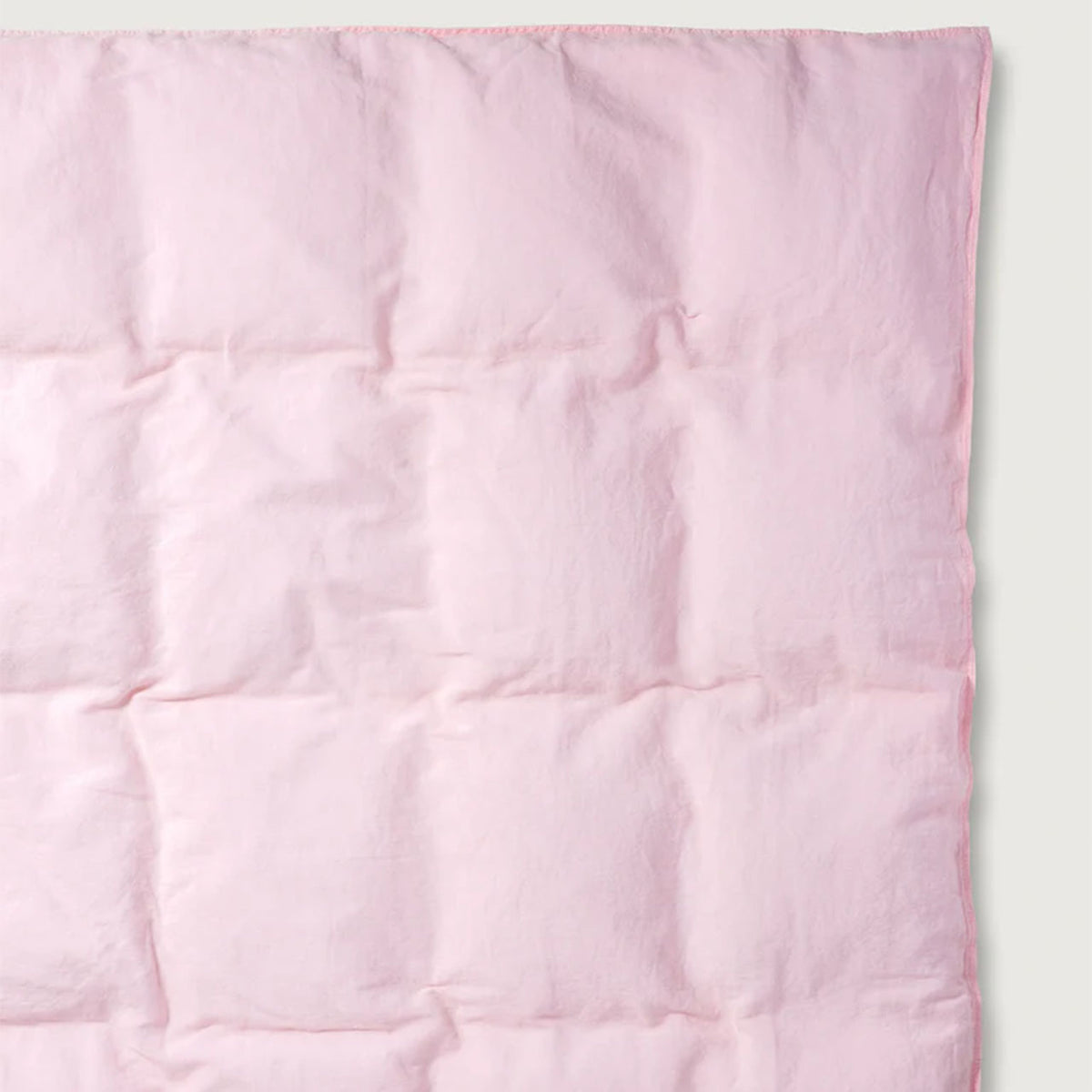 Nahaufnahme des Suite702 Leinen-Mix Bettdeckenbezugs in Shell Pink mit sichtbarer Kassettensteppung