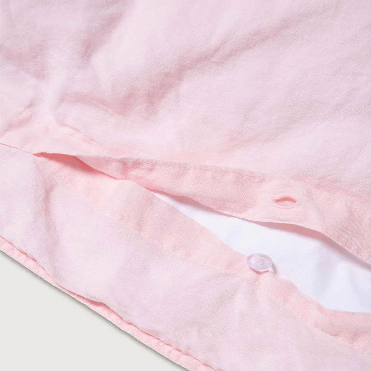 Nahaufnahme der Knopfleiste des Suite702 Leinen-Mix Bettdeckenbezugs in Shell Pink