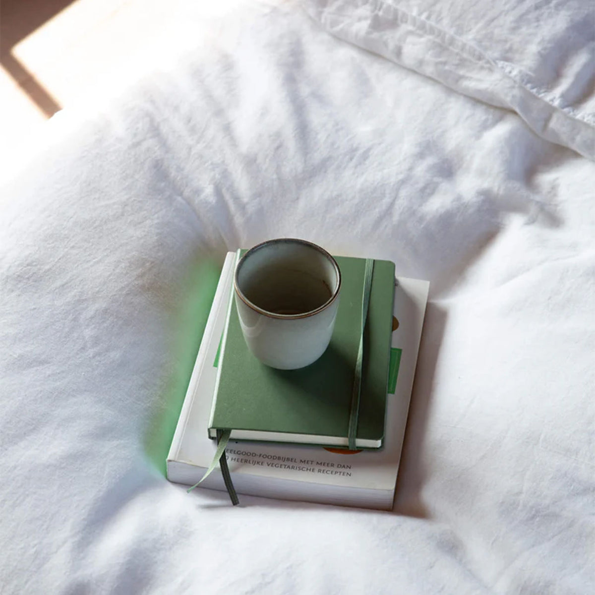 Suite702 Leinen-Mix Bettdeckenbezug in Weiß, Szene mit Buch und Kaffeetasse auf dem Bett