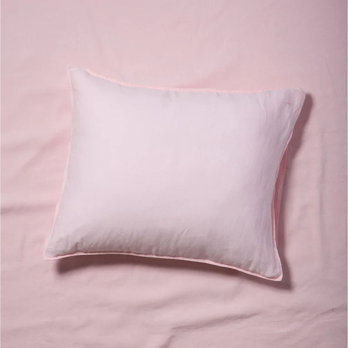Suite702 Leinen-Mix Kissenbezug in Shell Pink, liegend auf rosa Bettwäsche