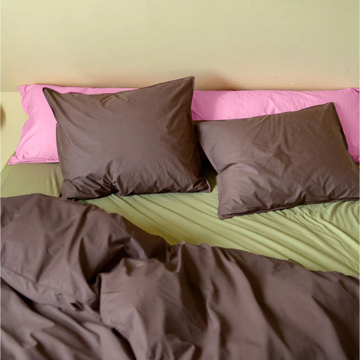 Suite702 Perkal Bettdeckenbezug in Coffee Brown auf Bett mit oliv- und rosafarbener Bettwäsche