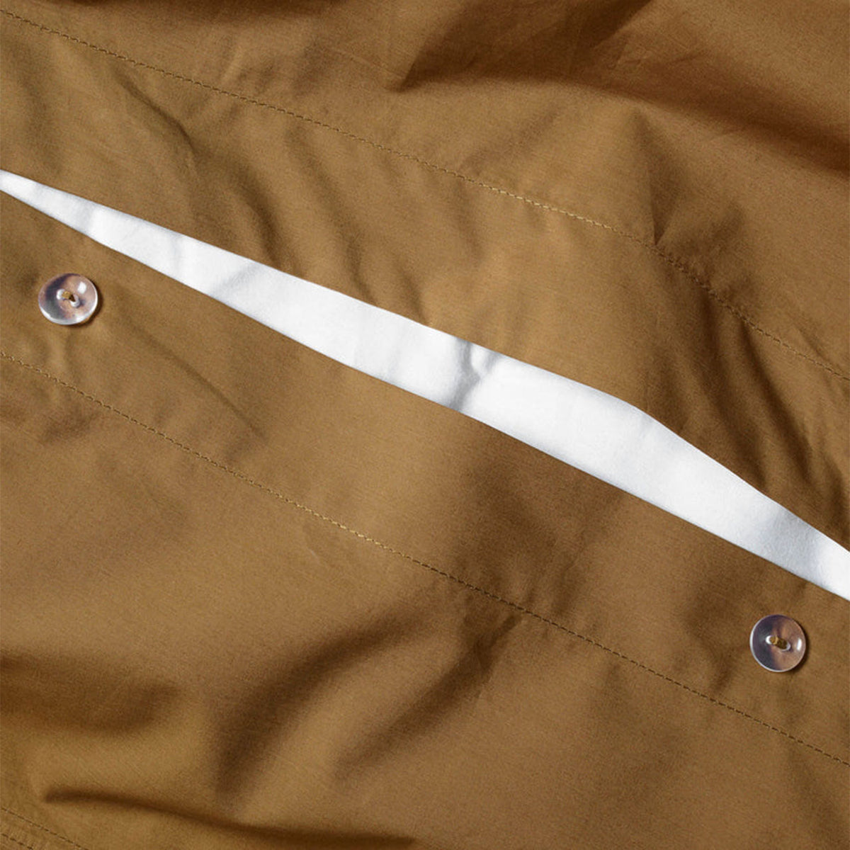 Nahaufnahme der Knopfleiste des Suite702 Perkal Bettdeckenbezugs aus Bio-Baumwolle in Khaki Gold