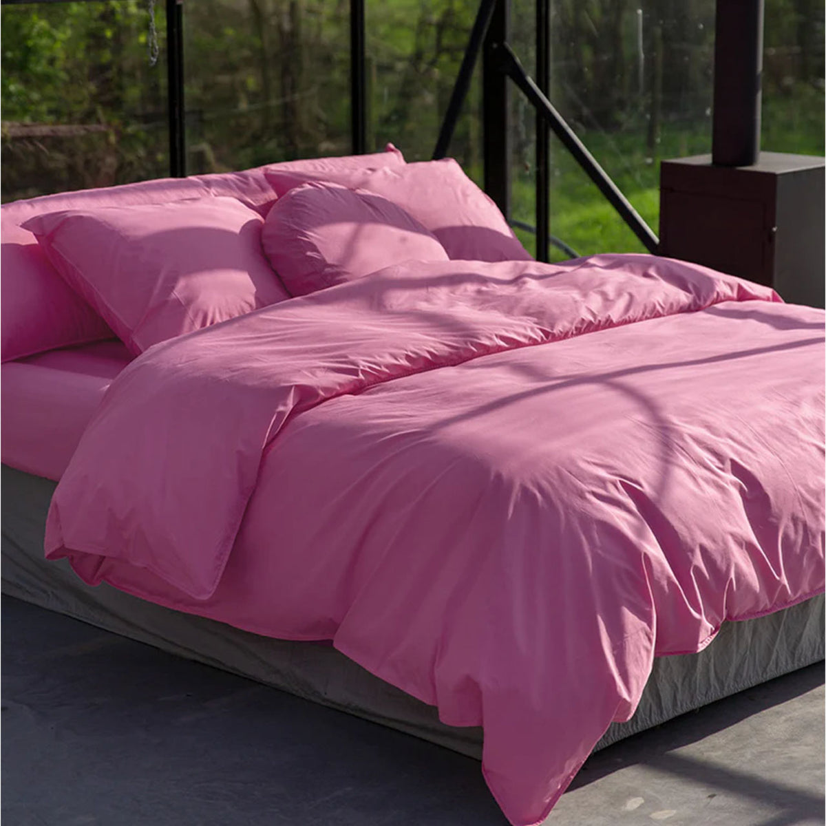 Suite702 Perkal-Bettdeckenbezug aus Bio-Baumwolle in Pink auf Bett im Gewächshaus, mit passenden Kissenbezügen