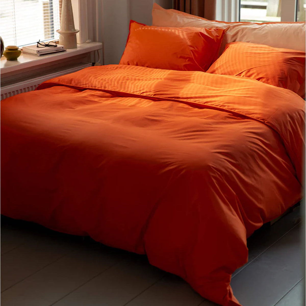 Suite702 Perkal Bettdeckenbezug aus Bio-Baumwolle in Orange, bezogenes Bett am Fenster
