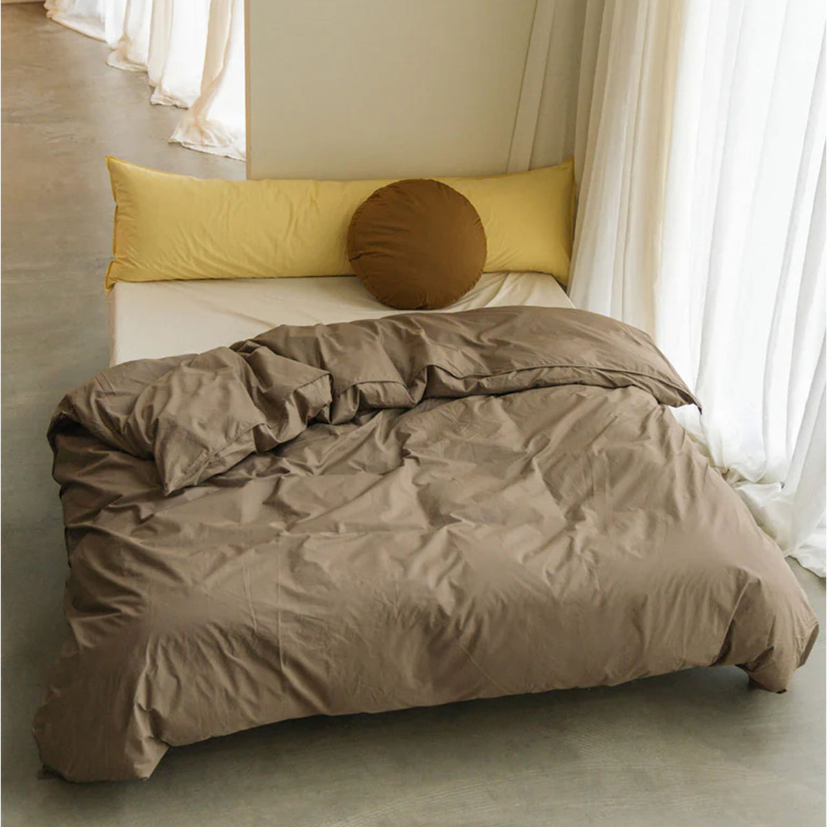 Suite702 Perkal Bettdeckenbezug aus Bio-Baumwolle in Smokey auf Bett mit gelben Kissen, Raumszene