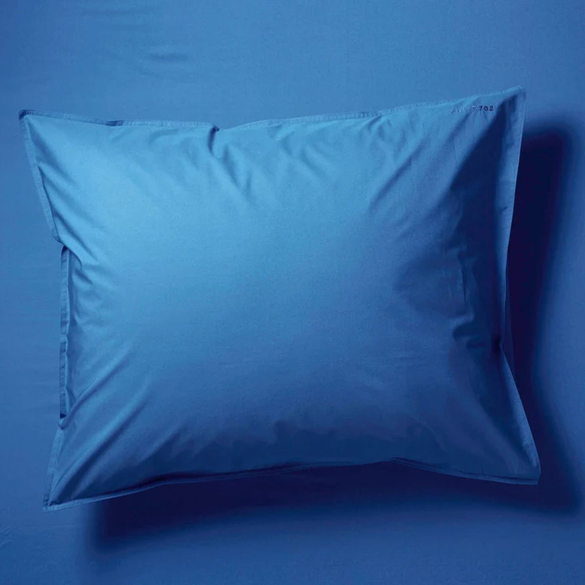 Suite702 Perkal Kissenbezug aus Bio-Baumwolle in Cobalt Blue, Gesamtansicht vor blauem Hintergrund